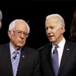 Joe Biden and Bernie Sanders on stage during a debate.