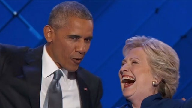 Democrat party members Hillary Clinton and Barack Obama laughing.