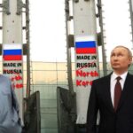 Vladimir Putin and Kim Jong-un standing next to Russian missiles.