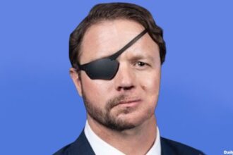 Dan Crenshaw with half his beard shaved.