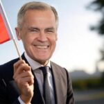 White male Mark Carney wearing a suit and waving a Canada flag.