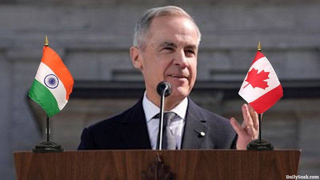 Mark Carney giving a speech on stage with a Canada flag and India flag.