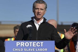 Gavin Newsom giving a speech in front of a podium on Donald Trump's ICE raids.