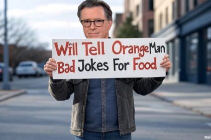 Late Show host Stephen Colbert standing on street corner holding a sign.