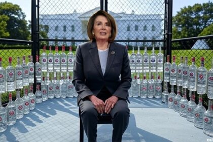 Nancy Pelosi inside of a cage with vodka bottles on Donald Trump's White House lawn.