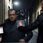 Two UK British men in a dark alleyway sharing memes to avoid the Online Safety Act.