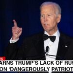 Joe Biden giving a speech on stage regarding Donald Trump's alleged Russia collusion.
