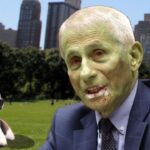 Dr. Fauci in a park next to a beagle dog.