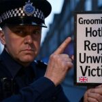 UK police officer holding a sign with the words "Grooming Gang Hotline."
