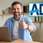 White man looking at a laptop on desk checking on ADL website.