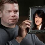 Male California Democrat Eric Swalwell sitting on a couch staring a picture frame with Asian woman Fang Fang in it.