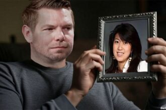 Male California Democrat Eric Swalwell sitting on a couch staring a picture frame with Asian woman Fang Fang in it.