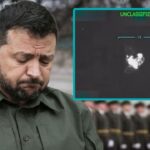 Ukraine President Zelensky with his head down in mourning in front of soldiers.
