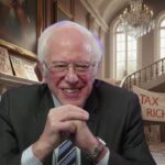 Bernie Sanders inside of his home next to "Tax the Rich" signs.