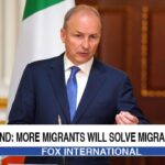 Ireland Prime Minister giving a speech on stage about migrant crisis.