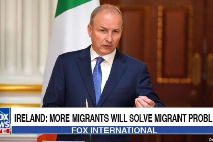 Ireland Prime Minister giving a speech on stage about migrant crisis.