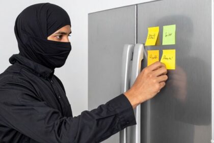 Islamic terrorist leaving a Post-It sticky note on a refrigerator.