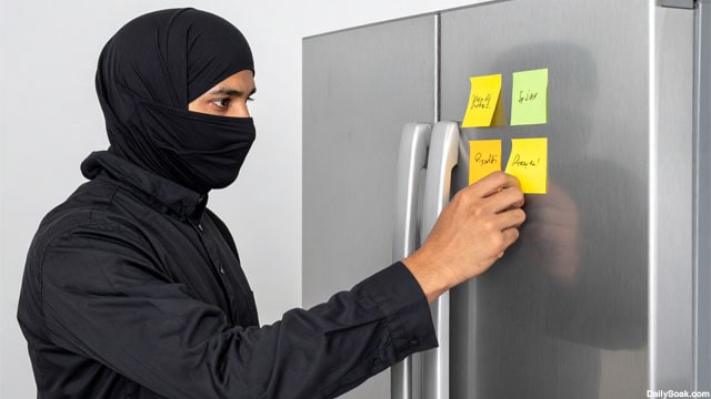 Islamic terrorist leaving a Post-It sticky note on a refrigerator.