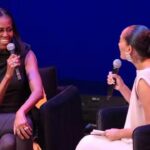 Michelle Obama on stage during an interview with another black woman.