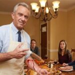 HHS Secretary RFK Jr. holding a syringe in front of a Thanksgiving turkey on a table.