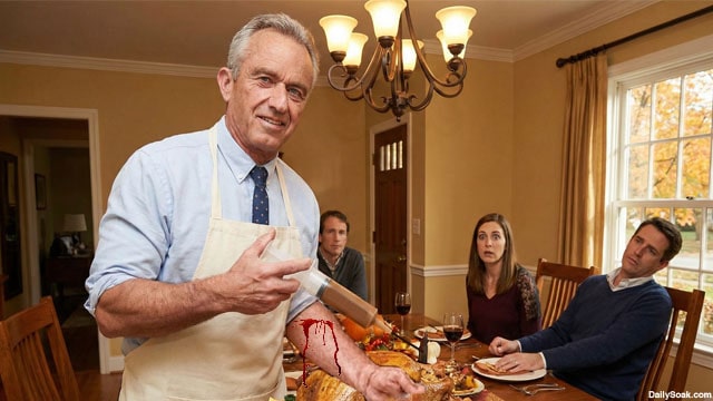 HHS Secretary RFK Jr. holding a syringe in front of a Thanksgiving turkey on a table.