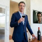 California Governor Gavin Newsom drinking wine inside of his mansion.