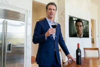 California Governor Gavin Newsom drinking wine inside of his mansion.