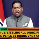 India official giving speech at podium regarding Indian H-1b visas.