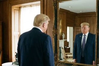 Donald Trump staring into a mirror in a large room.