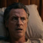 Gavin Newsom in bed waking up petrified from a nightmare.