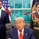 Marco Rubio wearing a Venezuela President uniform standing behind President Donald Trump inside of the White House.