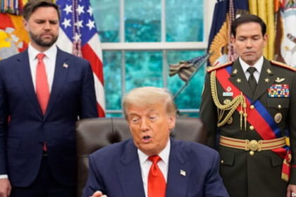 Marco Rubio wearing a Venezuela President uniform standing behind President Donald Trump inside of the White House.