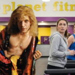 Transgender serial killer Buffalo Bill standing in front of a Planet Fitness gym.