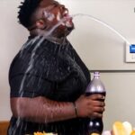 Fat black man with water being shot at his face by an RFK Jr. smart refrigerator.