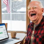 Tim Walz looking at laptop inside of home checking Polymarket.