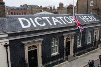 "Dicatato Here" painted in white paint on the roof of the British Prime Minister's office.