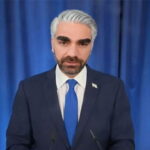 Jewish podcaster Ben Shapiro wearing a suit and a white wig posing as Israel Prime Minister Benjamin Netanyahu.