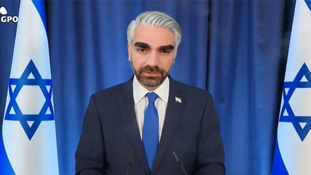 Jewish podcaster Ben Shapiro wearing a suit and a white wig posing as Israel Prime Minister Benjamin Netanyahu.