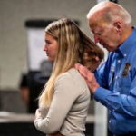 Joe Biden wearing a TSA uniform groping a woman in an airport terminal.