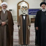Achmed the Dead Terrorist wearing Iranian clothing standing next to Iran leadership inside of a room.