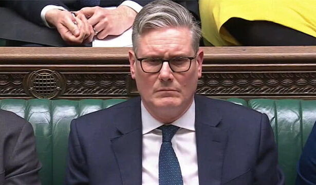 UK Prime Minister Keir Starmer sitting in Parliament at a seat.