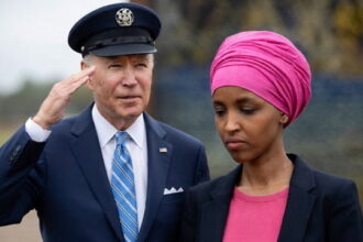 Joe Biden saluting Ilhan Omar outside during a speech.