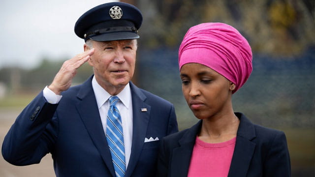 Joe Biden saluting Ilhan Omar outside during a speech.