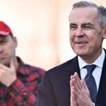 Canada Prime Minister Mark Carney wearing a suit and standing in front of a Canadian man wearing a flannel shirt.