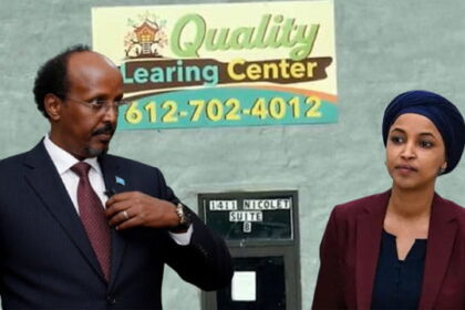 Ilhan Omar wearing Islamic clothing standing next to Somali man in front of Quality Learing Center.