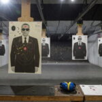 Gun range with target silhouettes of men wearing black suits and sunglasses resembling Secret Service agents.