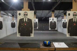 Gun range with target silhouettes of men wearing black suits and sunglasses resembling Secret Service agents.