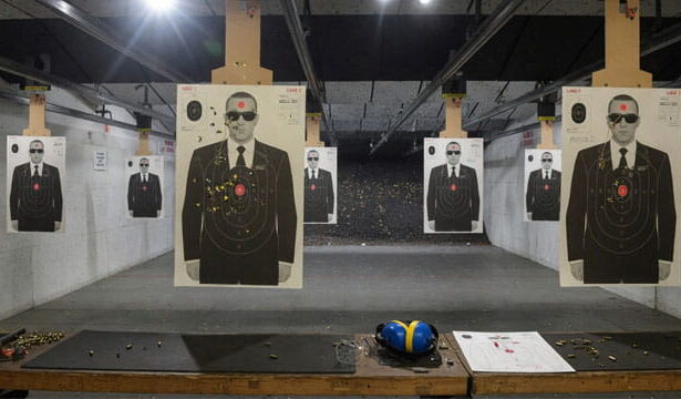 Gun range with target silhouettes of men wearing black suits and sunglasses resembling Secret Service agents.
