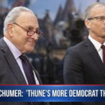Congress members Chuck Schumer and John Thune giving interview in Senate building.
