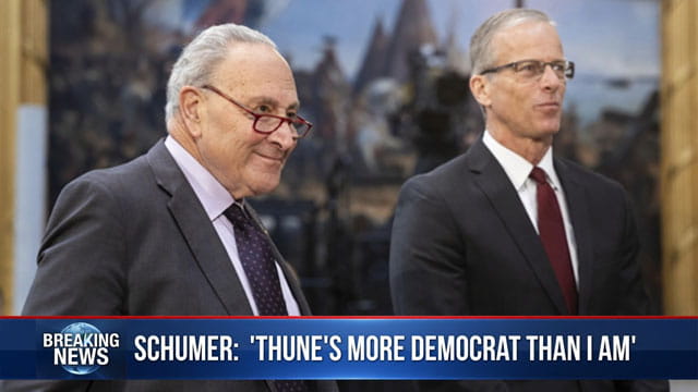 Congress members Chuck Schumer and John Thune giving interview in Senate building.